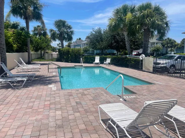 a view of a swimming pool with lounge chairs on th patio