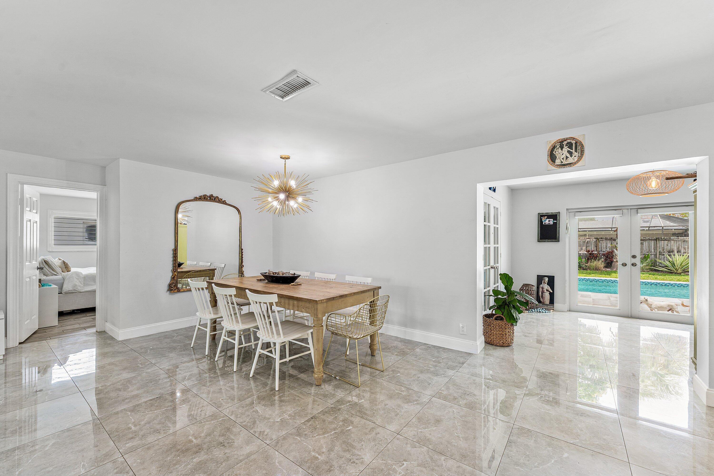 581 Northwest 13th Drive Boca Raton, FL 33486 - Photo 15 of 39 a dining room with furniture a chandelier and a rug