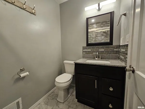 a bathroom with a sink vanity mirror and toilet