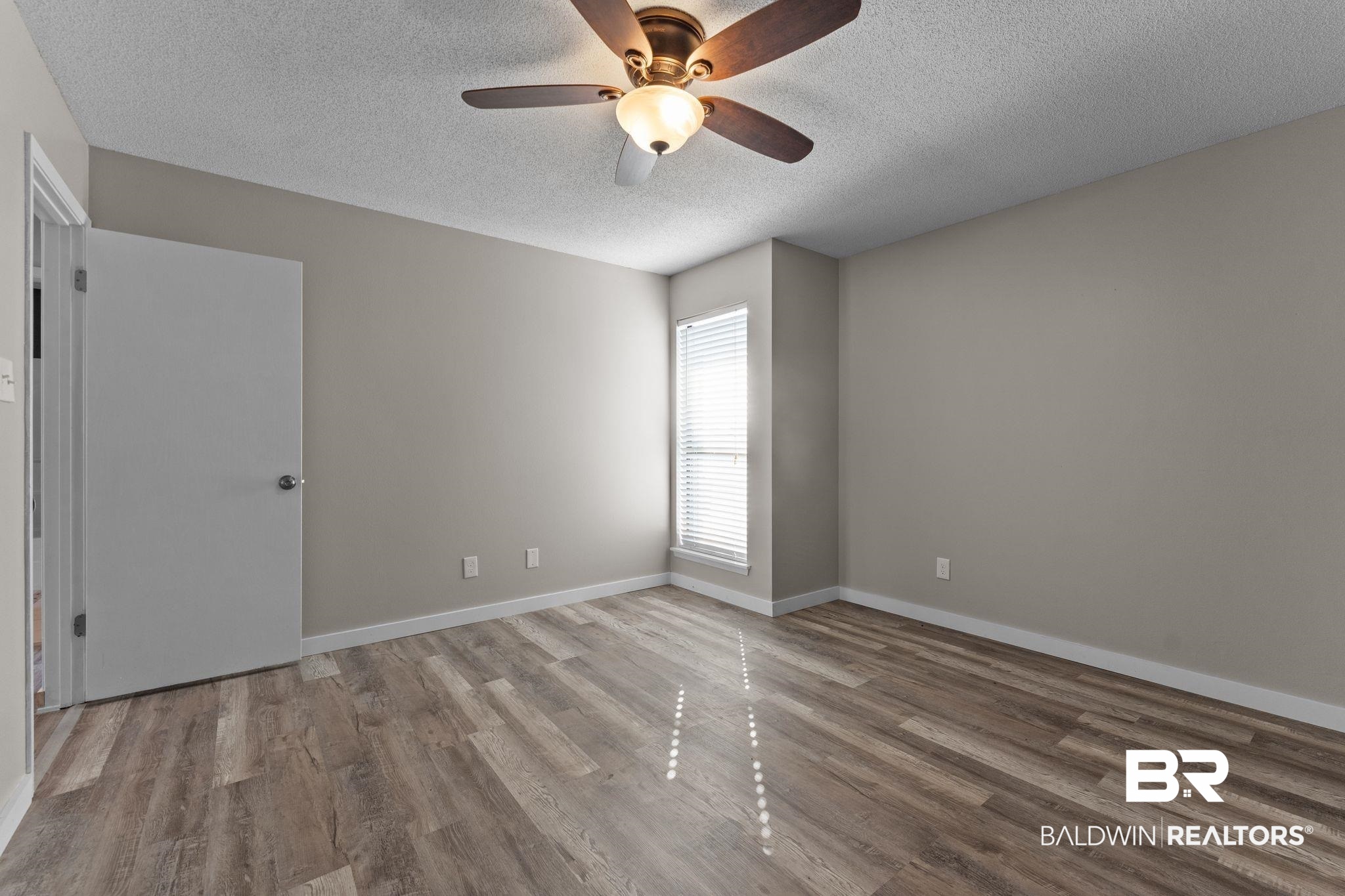128 West Satsuma Avenue, Unit 128 Foley, AL 36535 - Photo 19 of 41 Empty room featuring light wood-style floors, a textured ceiling, and a ceiling fan