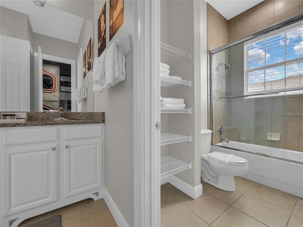1231 Radiant Street Reunion, FL 34747 - Photo 18 of 26 a bathroom with a granite countertop sink a toilet and shower