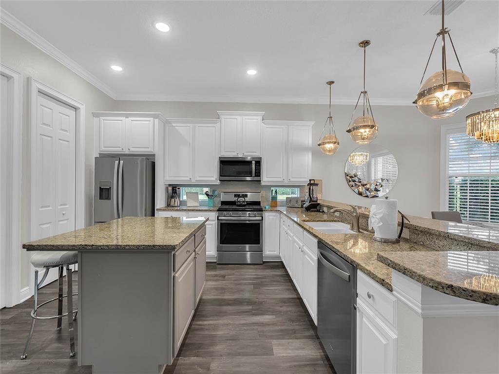 1231 Radiant Street Reunion, FL 34747 - Photo 2 of 26 a large kitchen with granite countertop lots of counter top space a sink and stainless steel appliances