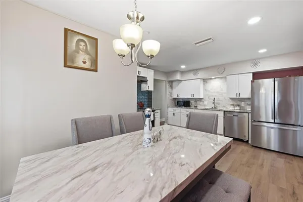 a large kitchen with a table chairs and a refrigerator