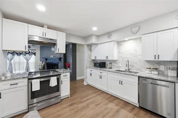 a kitchen with stainless steel appliances granite countertop a stove sink and cabinets