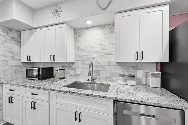 a kitchen with granite countertop a sink and cabinets