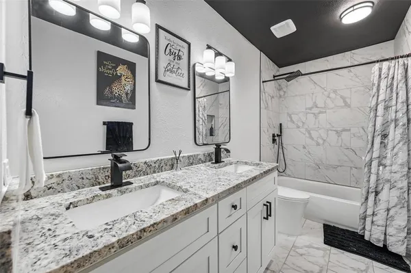 a bathroom with a granite countertop sink mirror and a bath tub