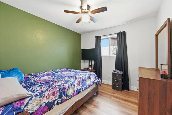 a bedroom with a bed and a flat tv screen on dresser