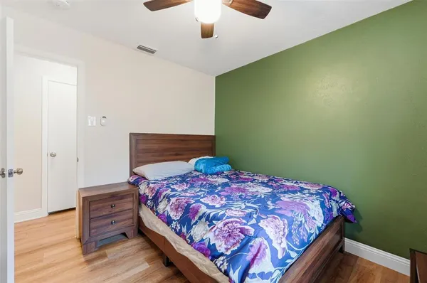 a bedroom with a bed and wooden floor