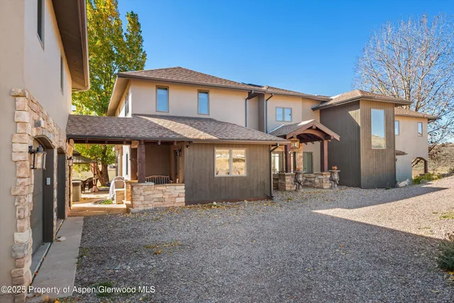 a kitchen with stainless steel appliances granite countertop a stove top oven a sink a dining table and chairs