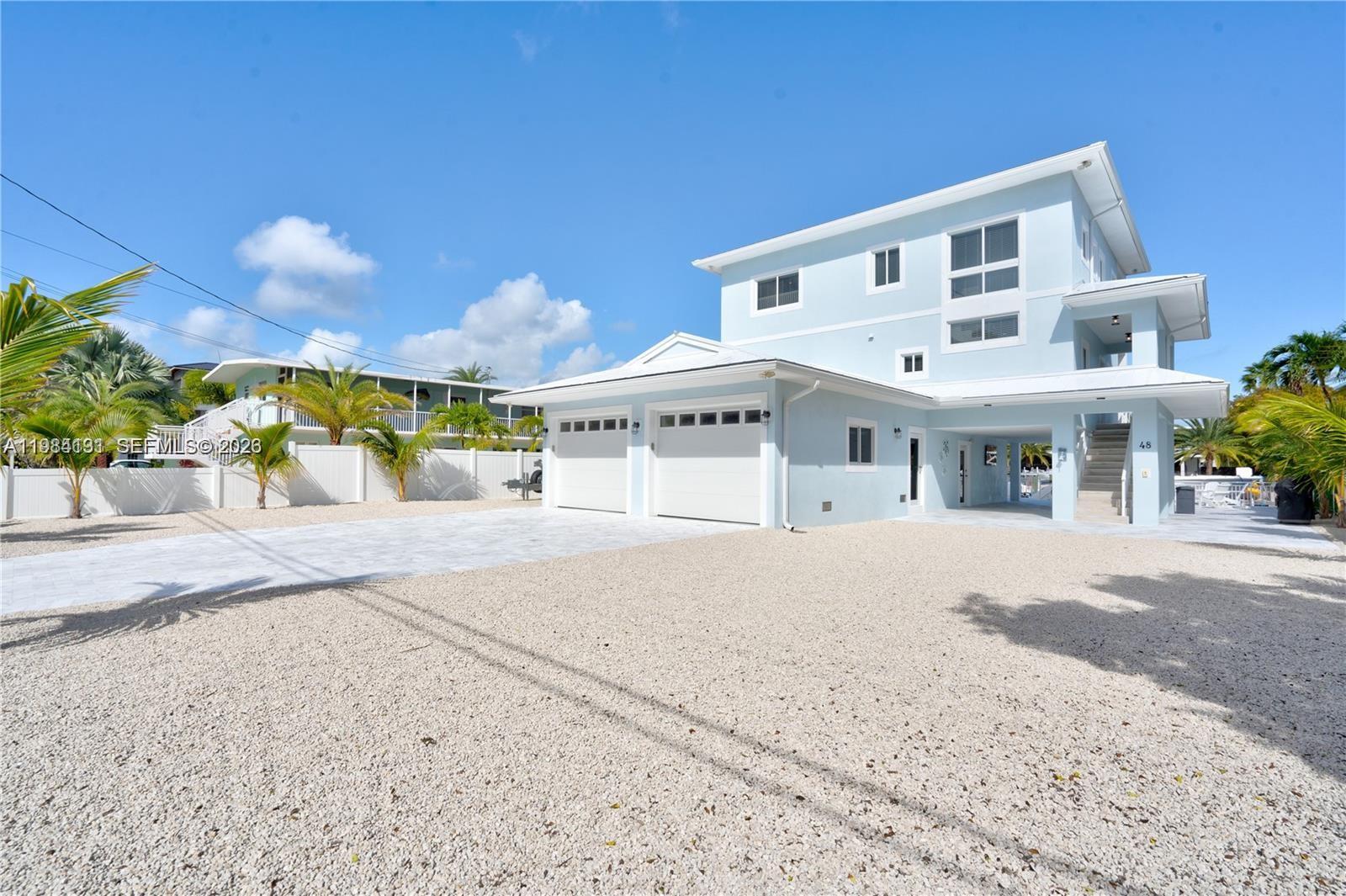 48 Andros Road Key Largo, FL 33037 - Photo 18 of 59 a front view of a house with a yard and a garage