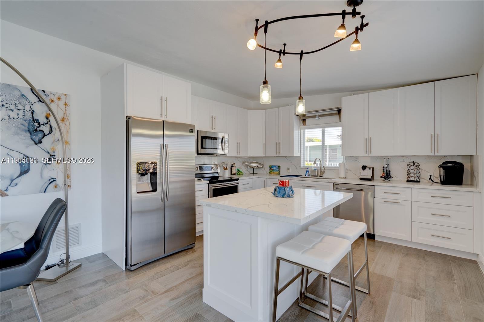 48 Andros Road Key Largo, FL 33037 - Photo 24 of 59 a kitchen with refrigerator cabinets and wooden floor
