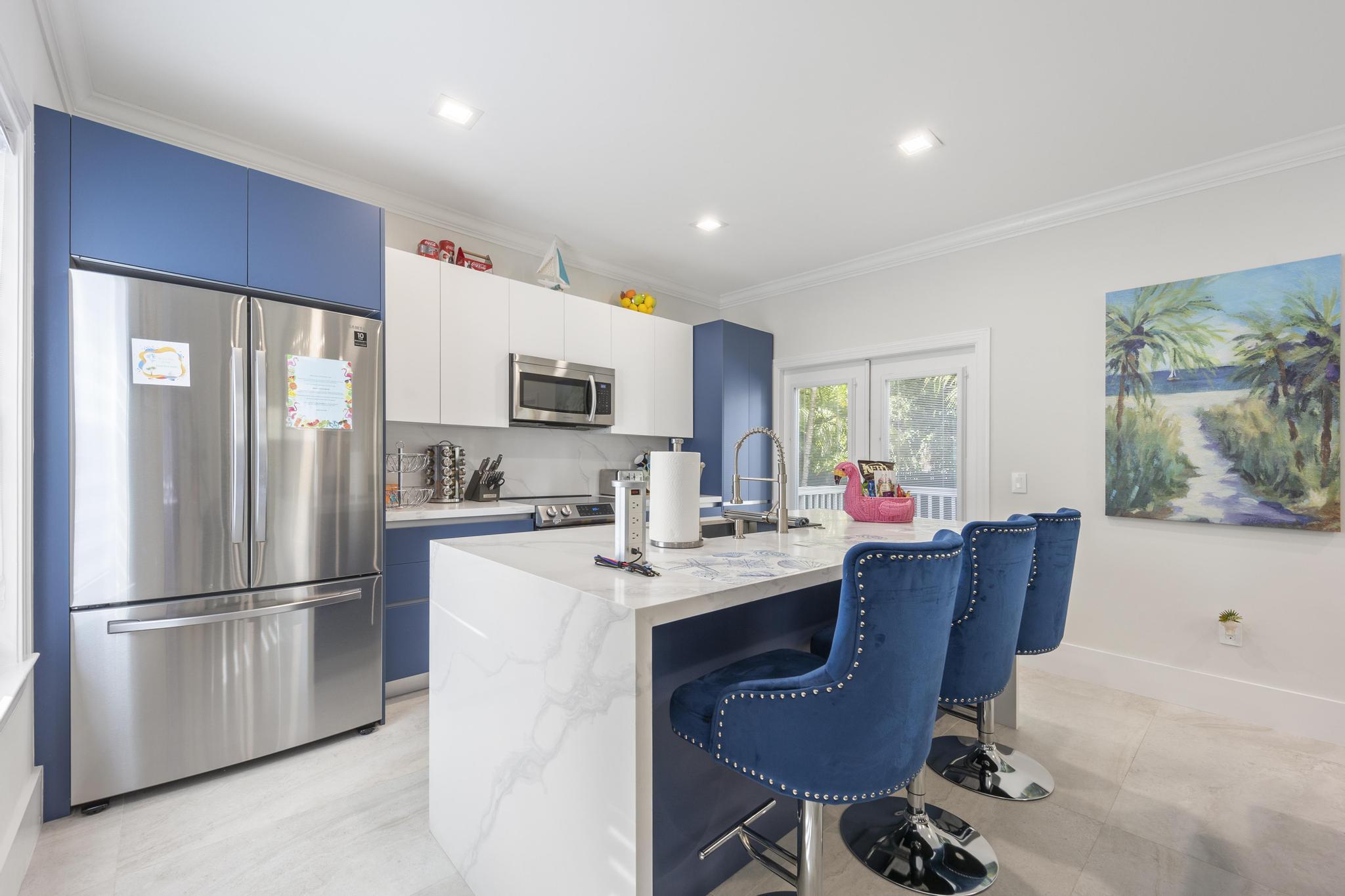 7213 Simran Lane Marathon, FL 33050 - Photo 7 of 40 a kitchen with stainless steel appliances a dining table chairs refrigerator and sink