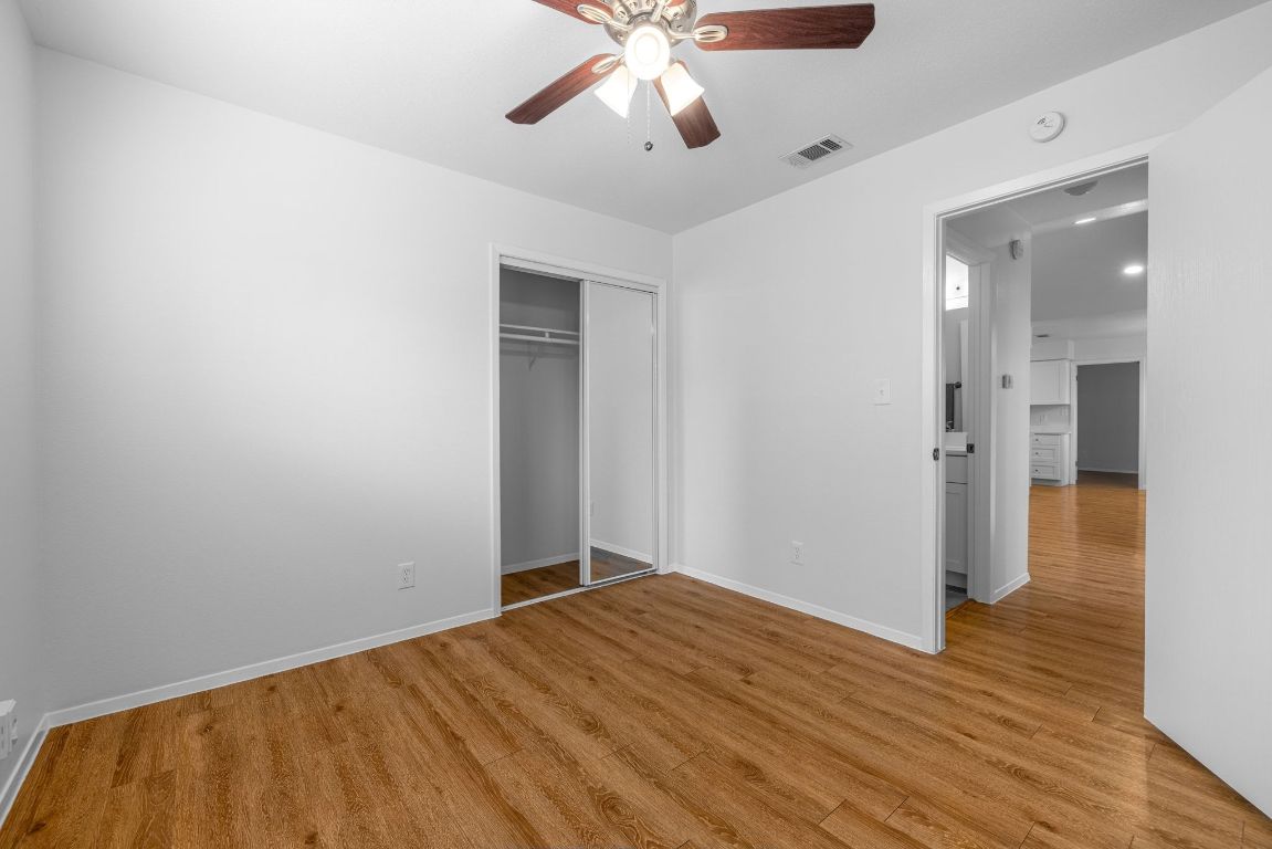 12801 Copper Cliff Avenue, Unit B Austin, TX 78727 - Photo 20 of 23 wooden floor in an empty room with a chandelier fan