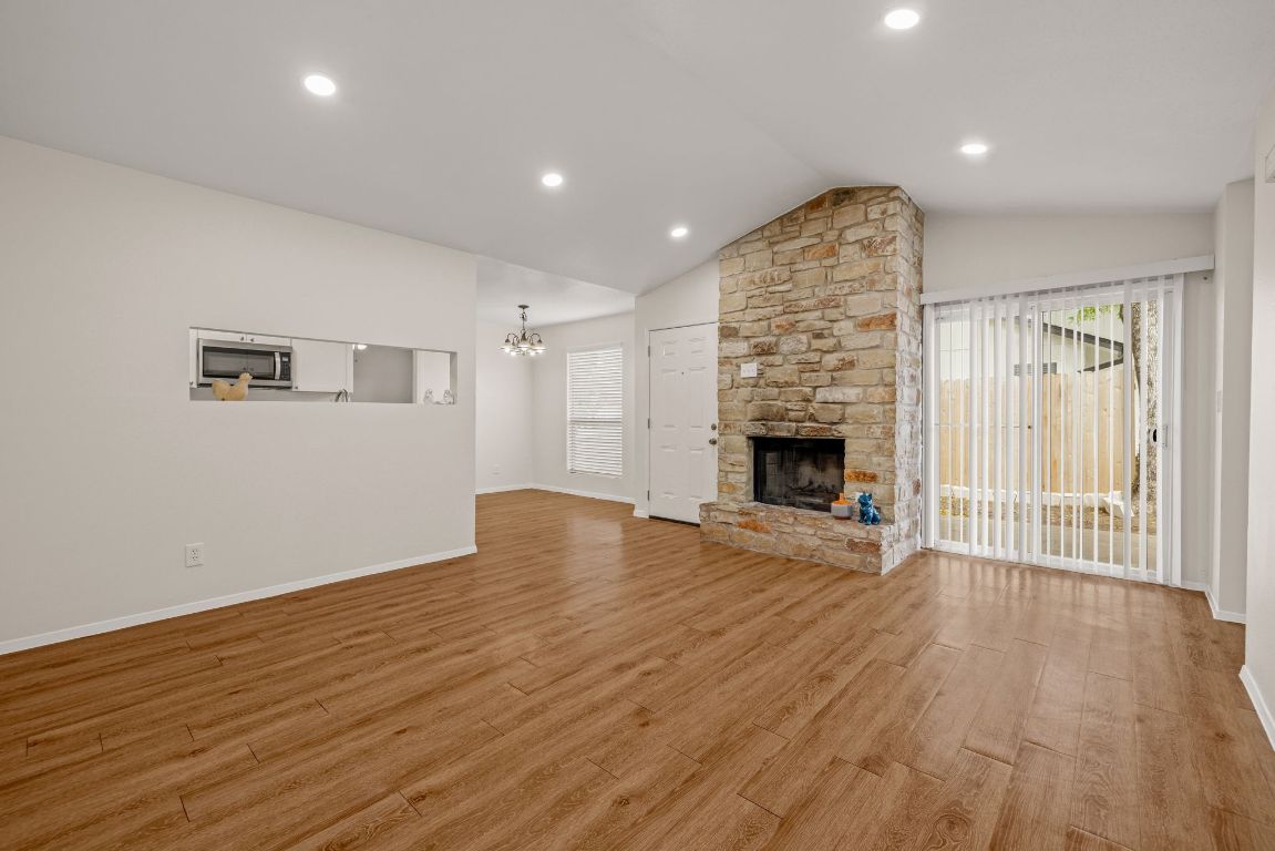 12801 Copper Cliff Avenue, Unit B Austin, TX 78727 - Photo 3 of 23 an empty room with wooden floor fireplace and windows