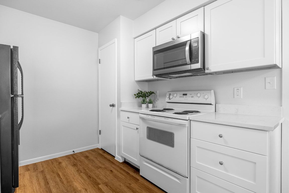 12801 Copper Cliff Avenue, Unit B Austin, TX 78727 - Photo 9 of 23 a kitchen with stainless steel appliances white cabinets and a sink