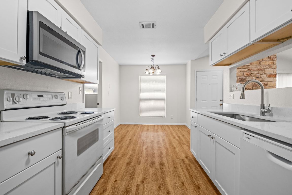 12801 Copper Cliff Avenue, Unit B Austin, TX 78727 - Photo 10 of 23 a kitchen with a sink stove and microwave