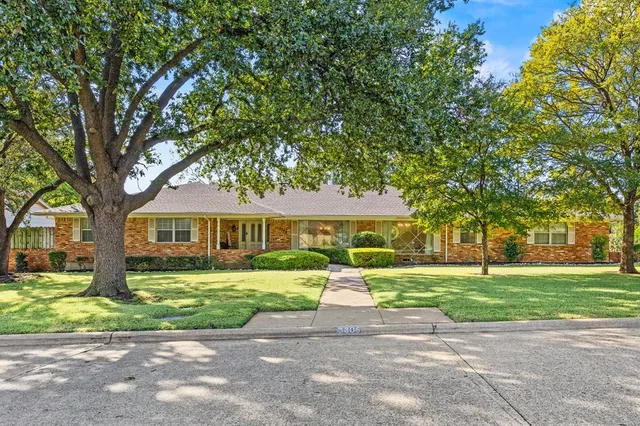 a front view of a house with a yard and trees