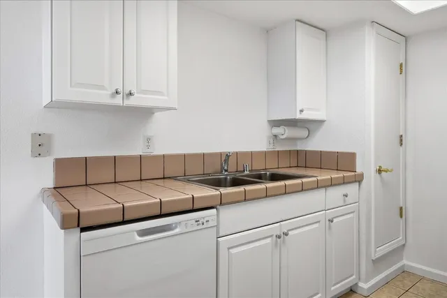 a kitchen with granite countertop white cabinets and a sink