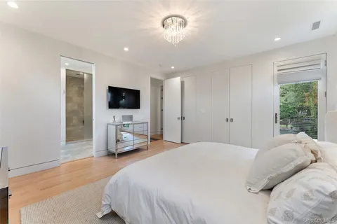 a bedroom with a large bed and a chandelier