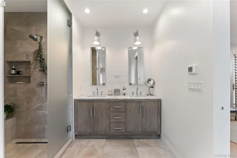 a bathroom with a double vanity sink mirror and shower