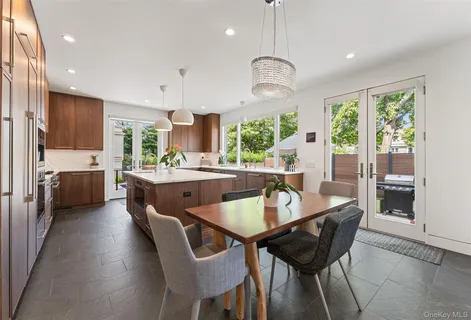 a kitchen with a dining table chairs stainless steel appliances and cabinets
