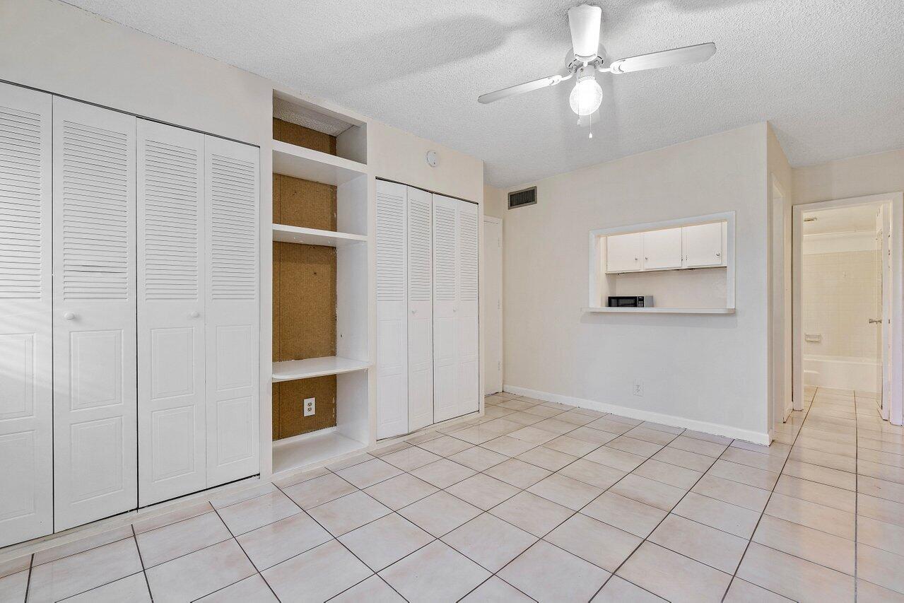 701 Pine Drive, Unit 210 Pompano Beach, FL 33060 - Photo 13 of 20 a view of an empty room with cabinet and a ceiling fan