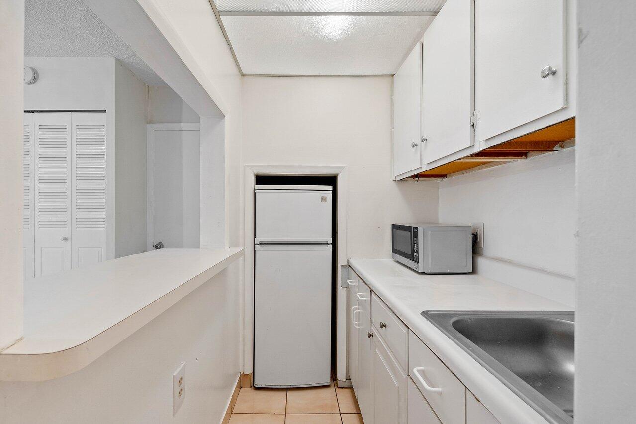 701 Pine Drive, Unit 210 Pompano Beach, FL 33060 - Photo 15 of 20 a kitchen with white cabinets and a sink