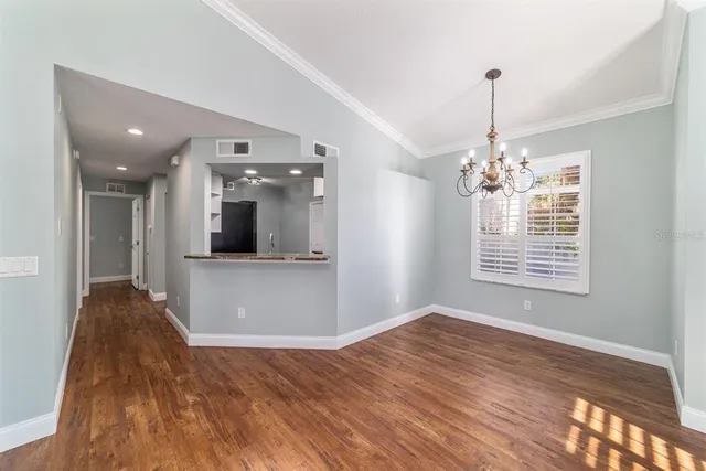 a view of a livingroom with a chandelier wooden floor and a chandelier