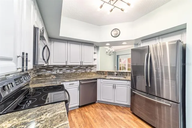 a kitchen with stainless steel appliances granite countertop a stove and a sink