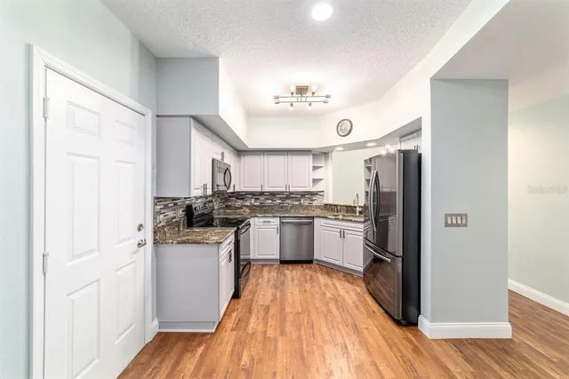 a view of a kitchen with a sink and refrigerator