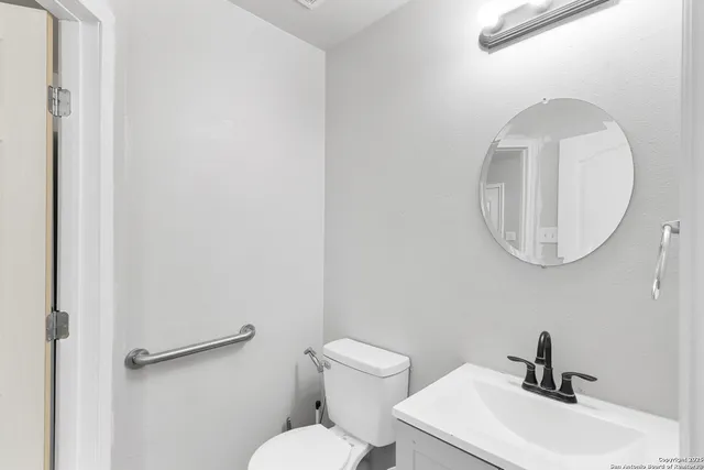 a bathroom with a toilet a sink and mirror