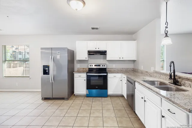 a kitchen with stainless steel appliances granite countertop a refrigerator and a stove