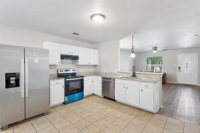 a kitchen with granite countertop white cabinets and white appliances