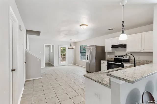 a kitchen with stainless steel appliances granite countertop a sink refrigerator and microwave