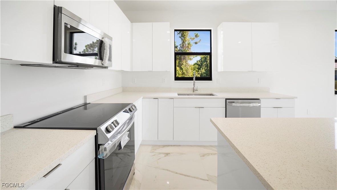 121 Ichabod Avenue Lehigh Acres, FL 33973 - Photo 18 of 42 a kitchen with a sink cabinets and window