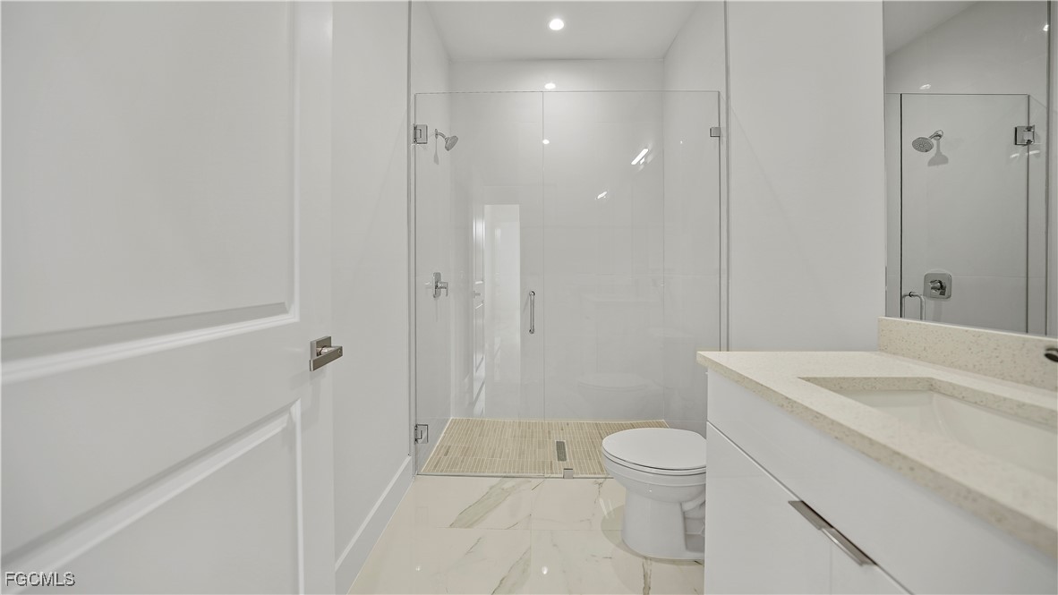 121 Ichabod Avenue Lehigh Acres, FL 33973 - Photo 25 of 42 a bathroom with a sink a toilet and shower