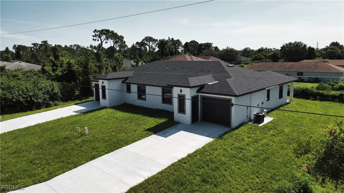 121 Ichabod Avenue Lehigh Acres, FL 33973 - Photo 3 of 42 a aerial view of a house with a yard table and chairs