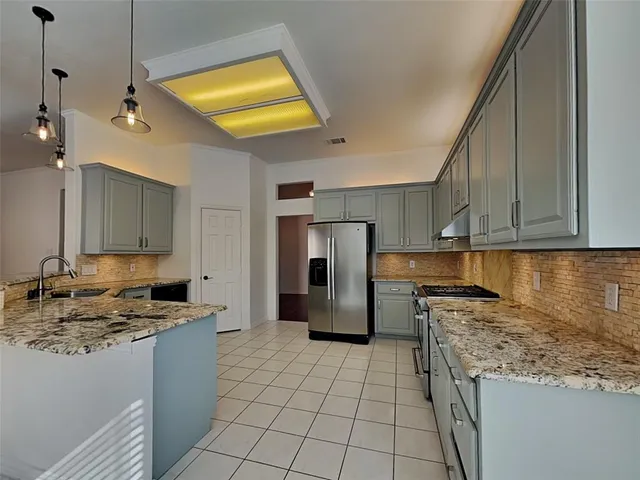 a kitchen with a refrigerator a sink and a stove