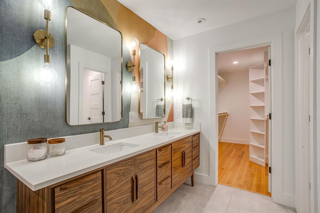 6700 Fortune Road Fort Worth, TX 76116 - Photo 29 of 40 Double vanity with wood-finish cabinetry, white countertop, and gold-finish fixtures