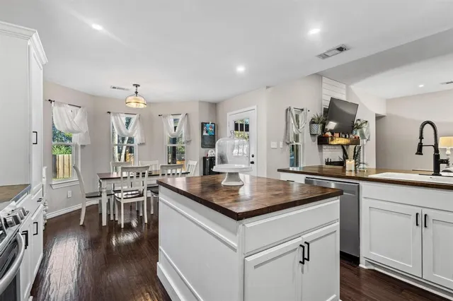 a kitchen with a table chairs stove and wooden floor