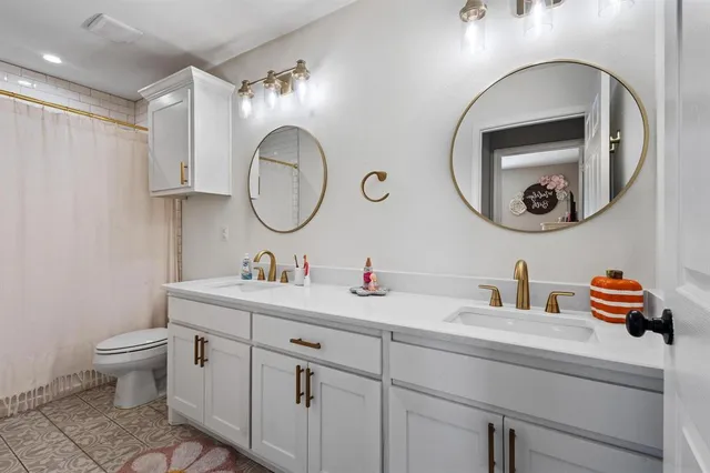 a bathroom with a toilet a sink and a mirror