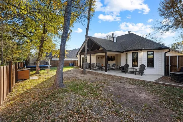 a view of a house with backyard and a tree