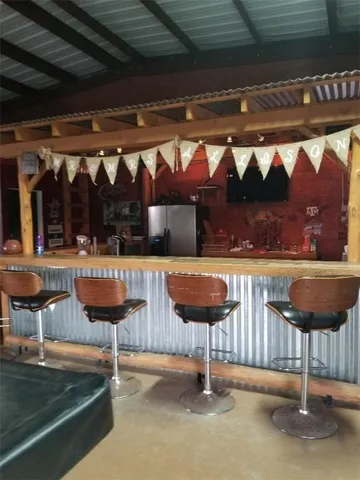 a view of the patio with dining table and chairs with plants