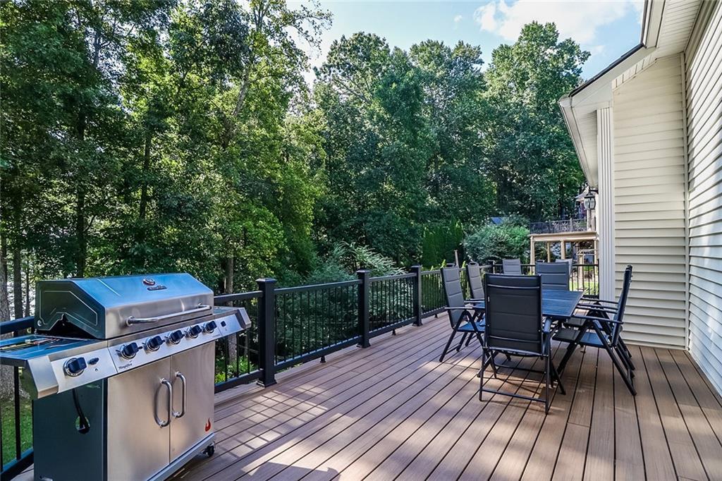 6150 Six Mile Cove Road Cumming, GA 30041 - Photo 19 of 27 a view of a deck with table and chairs with wooden floor and fence