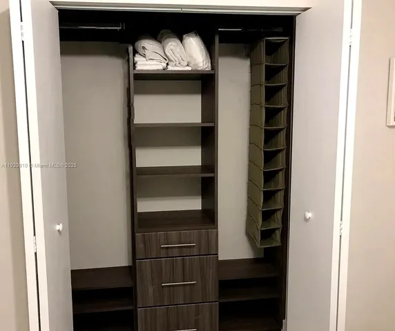 a view of walk in closet with empty racks