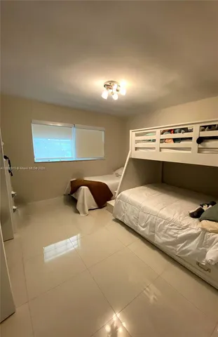 a bedroom with a bed and painting on the wall