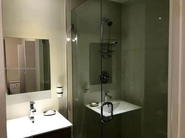 a bathroom with a sink a mirror and shower