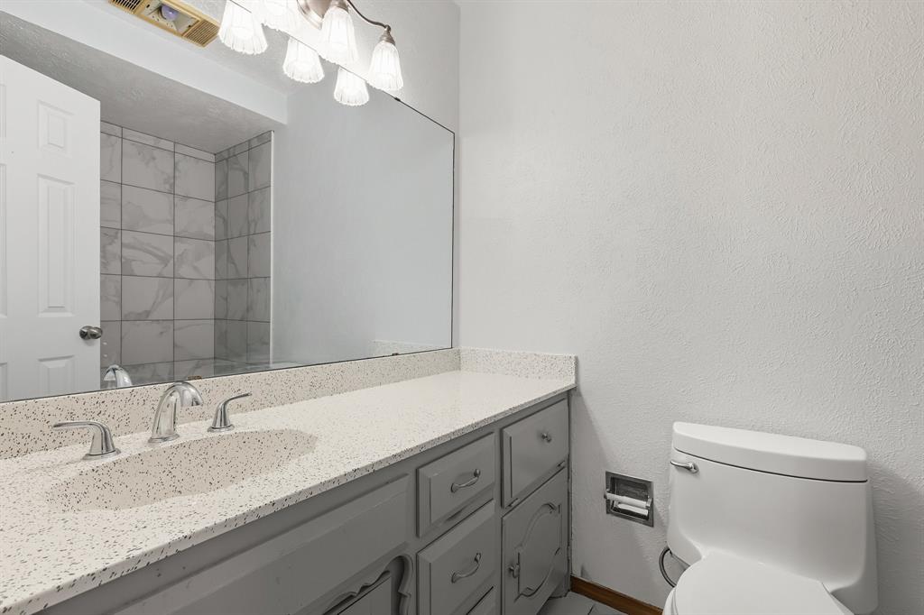 3300 Dunes Street Denton, TX 76209 - Photo 26 of 40 a bathroom with a granite countertop sink a toilet and a mirror