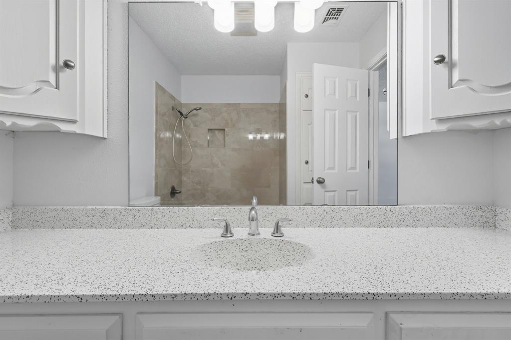 3300 Dunes Street Denton, TX 76209 - Photo 33 of 40 a bathroom with granite countertop a sink and a mirror