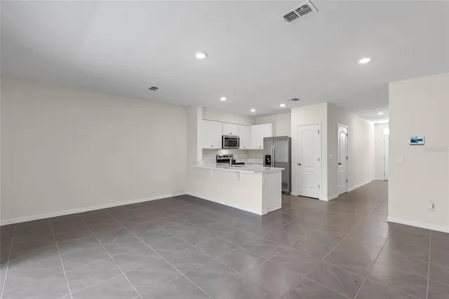 a kitchen with a refrigerator and white cabinets